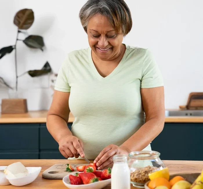 A woman preparing fresh fruit in her kitchen, the everyday routine SugarReset is designed to fit into